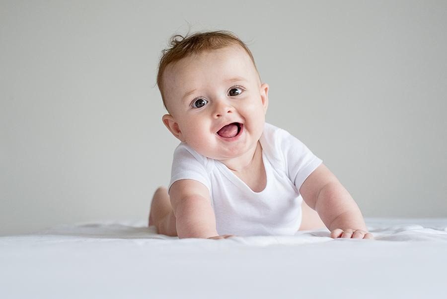 Bebê sorrindo na luz suave da janela